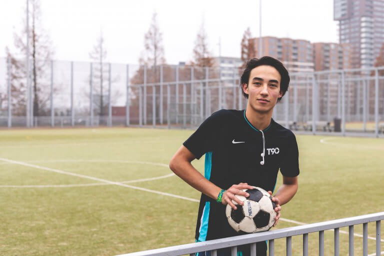 Voetballer met bal op voetbalveld